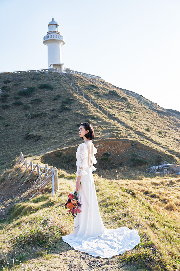 五島リトリート ray 灯台のふもとの草原で一人静かに佇む新婦