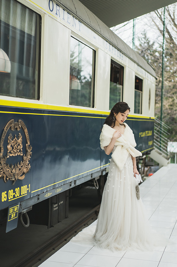 箱根リトリート オリエント急行前でケープを着用して佇む新婦
